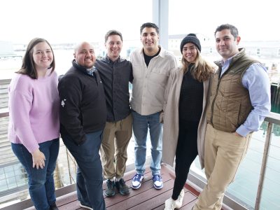 campfire team standing on a deck with portland waterfront as background